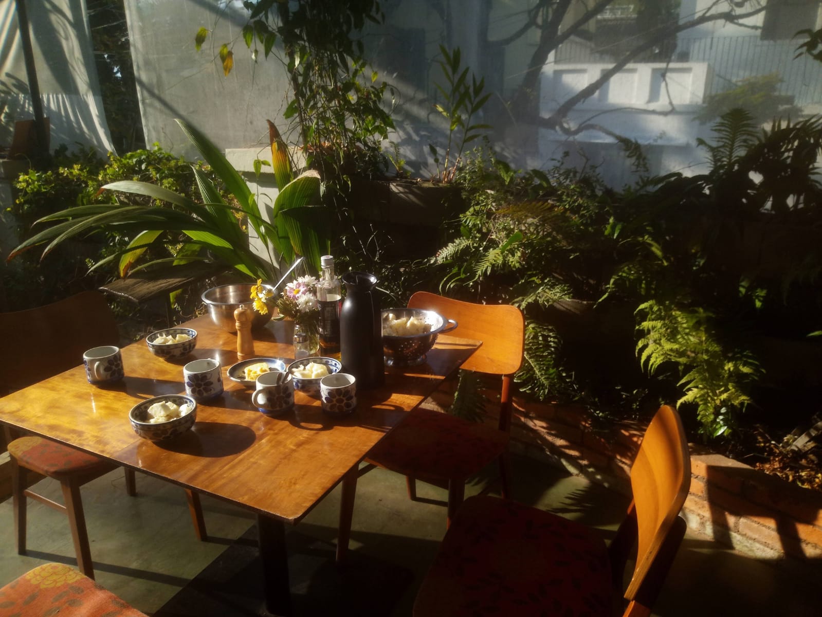 Mesa de café da manhã ao sol no jardim da Pousada Ziláh